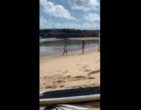 Man in white shirt tiktok dance at beach