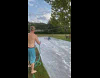 Truck pulls guy across soapy plastic tarp 