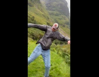 Man on mountain wiggles pushed by wind