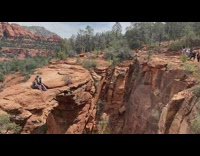 Family sits on the edge cliff of the canyon