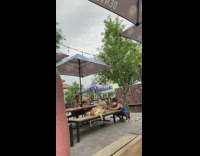 Girl squats photographs dog picnic table restaurant 