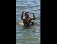 Shirtless guy black dog lake catches beer 