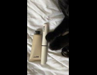 Pet cat plays with the beauty products on the bed
