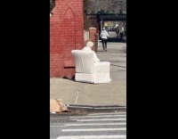 Old lady sits at chair on street