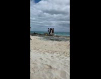 4 women pose on beach while 2 british women laugh and drink