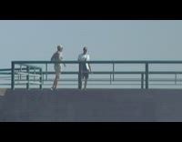 Man leg split on railings ocean laugh