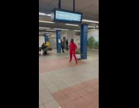 People in subway station watching man dance to music