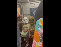 Man and Woman wears Stormtrooper helmet inside the train