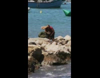 Woman on rock pier pictures selfie stick