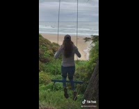 Girl falls off tree swing down hill