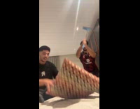Two guys act hit pillow with broom 