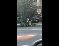 Man carrying road sign on street