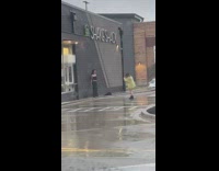 Woman in black dress poses in the rain