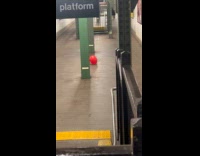 Red balloon on ground in train station