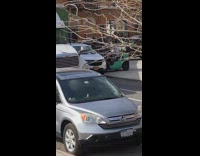 Person uses forklift to lift a parked vehicle out of the way