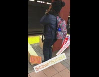 Woman with flower backpack dances with no music on in subway station