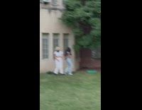 Two women tiktok dance in front of the window