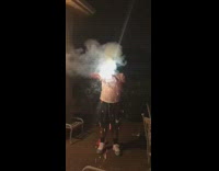 Guy holds and lights firework and records with phone, explodes in hand