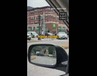 White shirt guy crosses street brick building