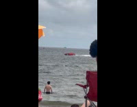 Man rides red car at the beach