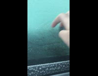 Person scratch glass of ice covered car