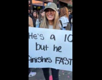 Woman shows funny marathon finishes fast sign 