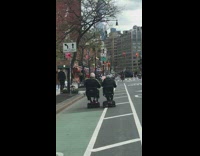 Two Old Men Ride their Travel Scooters Next to Each other in Bike Lane 
