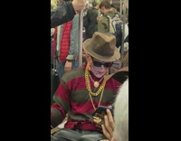 Guy in halloween costume riding subway using phone