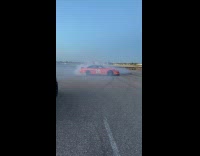 Red car doing donuts on runway