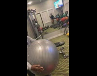 Boy jumps on running treadmill with gray yoga exercise ball, flips over and scorpions in gym