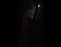 Guy inside house watches rain night time 