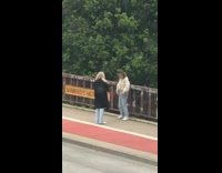 Lady Tries to Pose on Bridge but Gets Shy When she Sees Filmer
