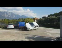 Man in small white car flips car