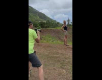 Woman in black tank top poses on the hill