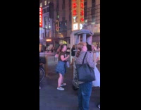 People petting cats on cat condo on street