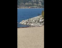 Man black shirt film himself talk beach seaside