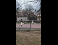 Girl takes picture in tennis court 