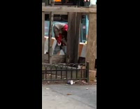 Guy puts imaginary friend in headlock and punches him next to bus stop
