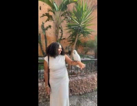 Woman poses with cockatoo standing on arm