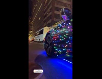 Car drive on street covered with Christmas lights