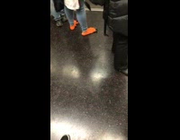 Woman wears orange monster feet shoes with claws on subway train