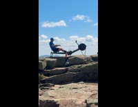 Man uses row machine on mountain top