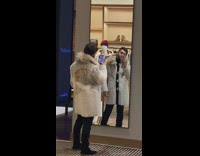 Guy try fur coat mirror selfie store 