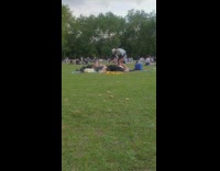 Guy stands over friends laying on grass 
