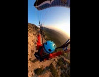 Guy flies around mountain on parachute