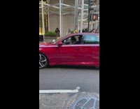 Guy dance and party inside his red car along the street 