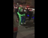 Guy green inflatable alien costume dances sidewalk 