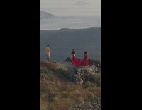 Woman with long red dress Santorini cliff