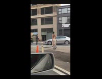 Woman in beaded dress rides electric unicycle hoverboard down the street