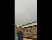 Video of a rainbow above the sky late in the afternoon